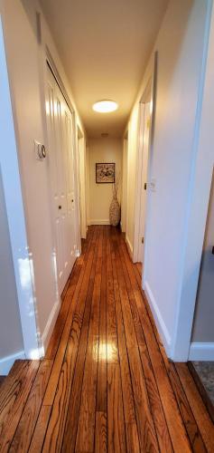 a hallway with a wooden floor in a house at New Seabury Retreat. Butchart Gardens' Inspired in Mashpee