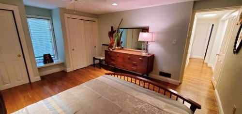 a room with a bed and a dresser and a mirror at New Seabury Retreat. Butchart Gardens' Inspired in Mashpee