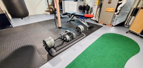 a gym with dumbbells and a green carpet at New Seabury Retreat. Butchart Gardens' Inspired in Mashpee