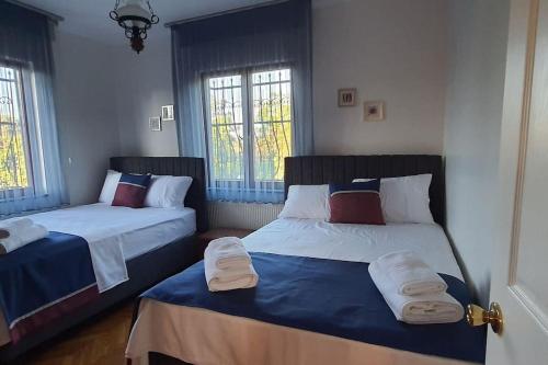 two beds in a room with two windows at Villa Koral in Kirkpinar - Sapanca in Sapanca