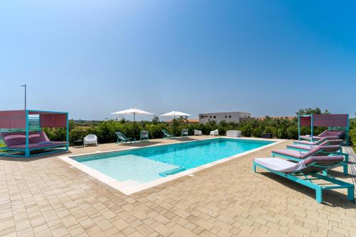 a swimming pool with chaise lounge chairs and a pool at Le scuderie 7 in Galatone