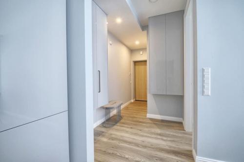 korytarz z białymi ścianami i drewnianą podłogą w obiekcie Cosy 3 room apartment. w Wilnie
