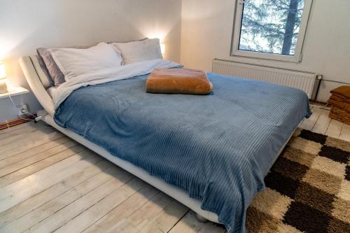 a large bed in a bedroom with a blue blanket at Cabana Misha in Băişoara