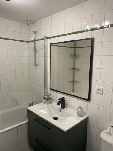 a bathroom with a sink and a large mirror at Logement de charme à Azay le Rideau in Cheillé