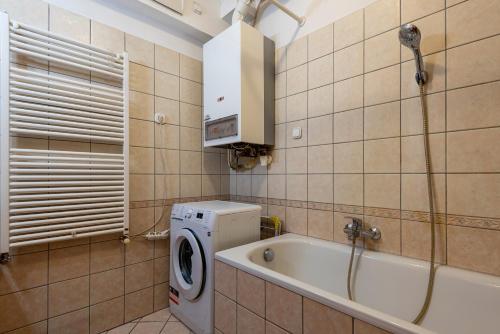 a bathroom with a washing machine and a bath tub at Pesti City Apartment&Free parking in Budapest