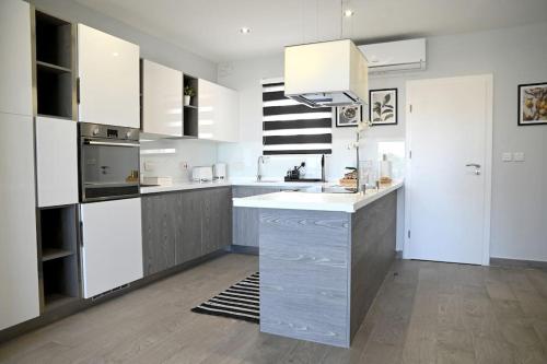 a kitchen with white cabinets and a counter top at 2 Bedroom Luxury Apartment in Madliena Swieqi in Is-Swieqi