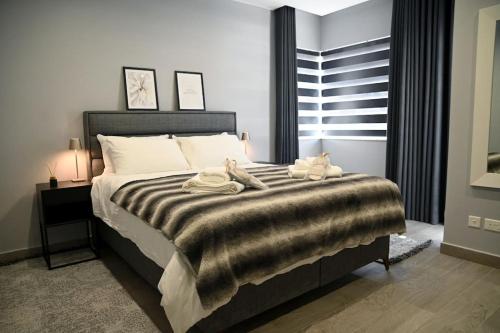 a bedroom with a bed with two stuffed animals on it at 2 Bedroom Luxury Apartment in Madliena Swieqi in Is-Swieqi