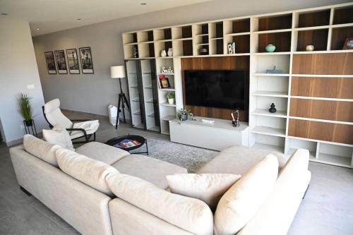 a living room with a white couch and a television at 2 Bedroom Luxury Apartment in Madliena Swieqi in Is-Swieqi