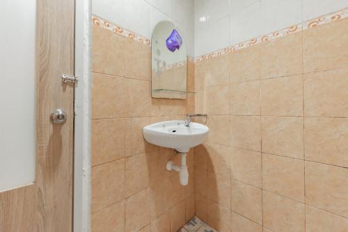 a bathroom with a sink and a mirror on the wall at RedDoorz Syariah near Taman Bekapai 2 in Klandasan Kecil