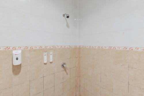 a shower in a bathroom with a shower head at RedDoorz Syariah near Taman Bekapai 2 in Klandasan Kecil