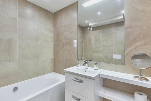 W łazience znajduje się umywalka, wanna i lustro. w obiekcie Apartament 70m2 przy parku Zdrojowym, plaża, centrum. w Świnoujściu