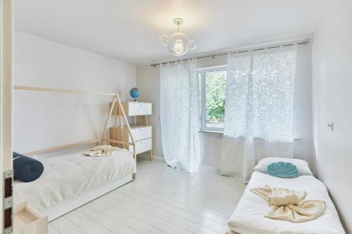 ein Schlafzimmer mit zwei Betten und einem Fenster in der Unterkunft Apartament 70m2 przy parku Zdrojowym, plaża, centrum. in Świnoujście