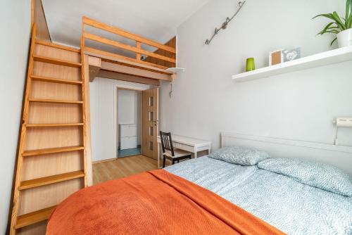 um quarto com uma cama com uma escada e uma secretária em Apartment in City Center em Gdańsk