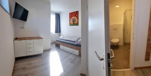 a small bedroom with a bed and a bathroom at RingRooms in Knittelfeld