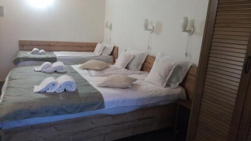 two beds with flip flops and towels on them at Family House in Buşteni