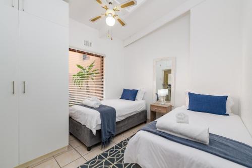 a bedroom with two beds and a ceiling fan at San Lameer Villa 1902 - 2 Bedroom Classic - 4 pax - San Lameer Rental Agency in Southbroom