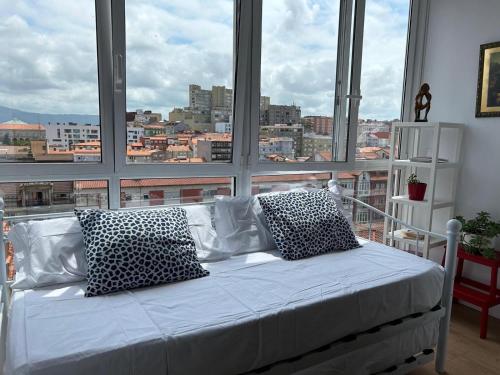 Cama en habitación con ventana grande en Cómodo y Moderno piso en el centro de Santander, en Santander