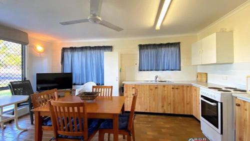 a kitchen and dining room with a table and chairs at Ocean Views in Burrum Heads