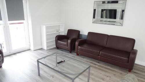 a living room with two couches and a glass coffee table at Cocoon @ International Inn + Apartments in Liverpool