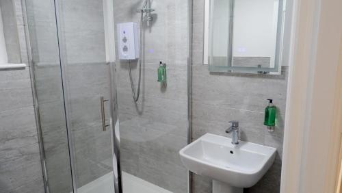 a bathroom with a shower and a sink at Cocoon @ International Inn + Apartments in Liverpool