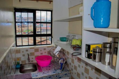 cocina con fregadero y ventana en BELEEN HOMES en Limuru
