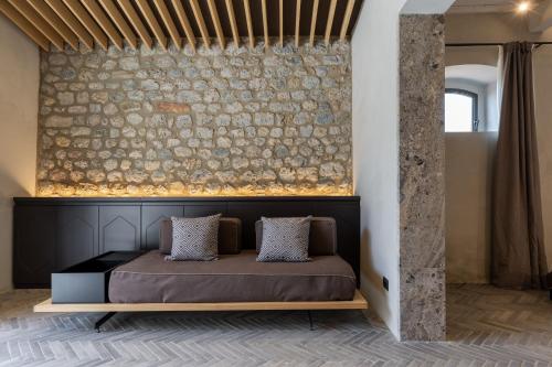 Posto letto in camera con parete in pietra. di Suite Mezzatorre a San Gimignano