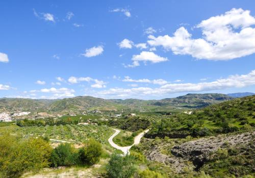 uma estrada nas colinas com montanhas ao fundo em El Capricho Villa Rural Caminito del Rey em Alora