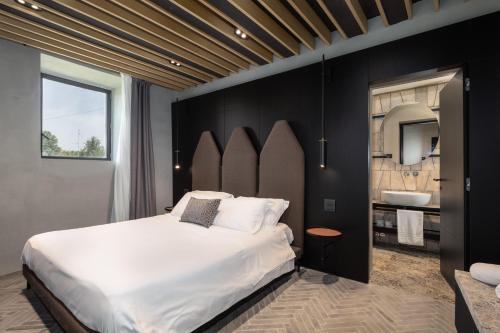 a bedroom with a large white bed and a bathroom at Suite Cantina in San Gimignano