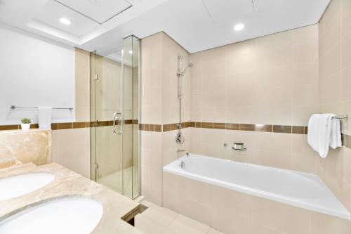 a bathroom with a tub and a sink and a shower at Designer 1BR 29 Boulevard Downtown Dubai Near Burj Khalifa in Dubai
