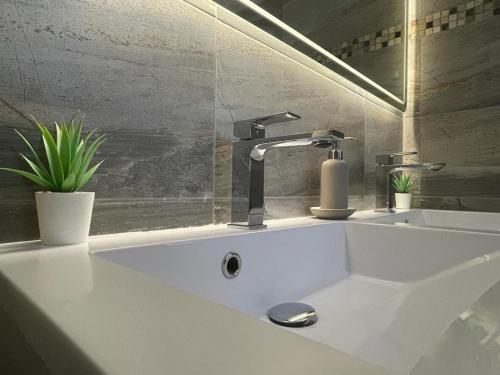 La salle de bains est pourvue d'un lavabo blanc et d'un robinet. dans l'établissement Hotel Roma, à Merzig