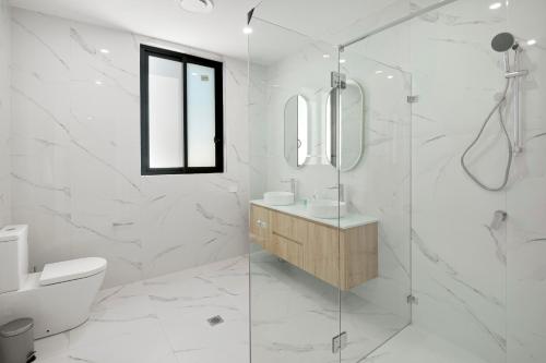 La salle de bains est pourvue d'une douche, de toilettes et d'un lavabo. dans l'établissement Lake View Suites Jindabyne, à Jindabyne