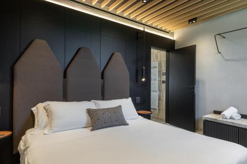 una camera da letto con un grande letto bianco e pareti nere di Suite Orcio a San Gimignano
