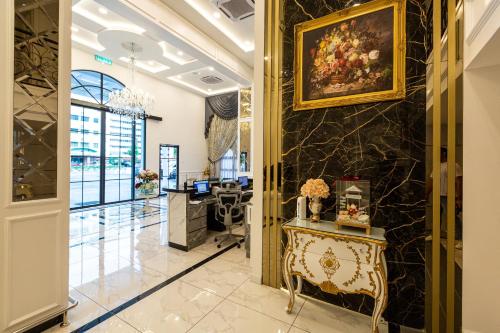 a lobby with a desk and a painting on the wall at Frazel Heritage Hotel in Alor Setar