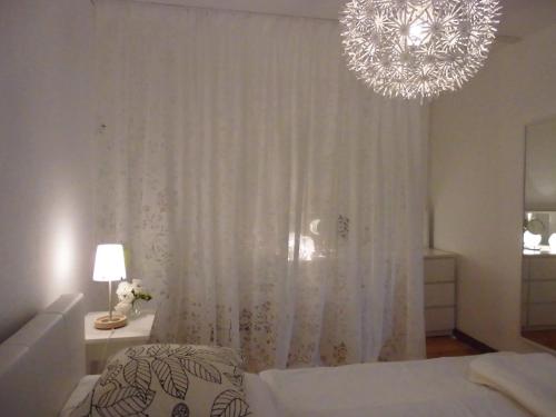 a bedroom with a bed and a chandelier at SchlossparkFerienwohnungen Rheinsberg mit Garten in Rheinsberg