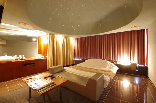 a hotel room with a bed and a table at Blue Hotel NAGI-Adult Only in Otaru