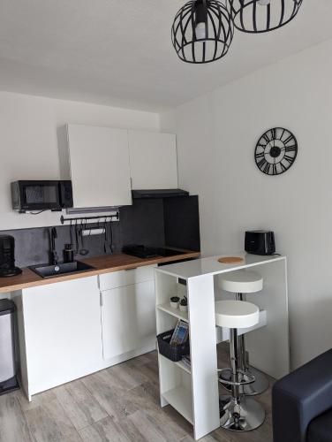 une cuisine avec des armoires blanches et un comptoir dans l'établissement Saint Mandrier Pin Rolland Studio Climatisé 2 pers parking plage pinède, tout à pied, à Saint-Mandrier-sur-Mer