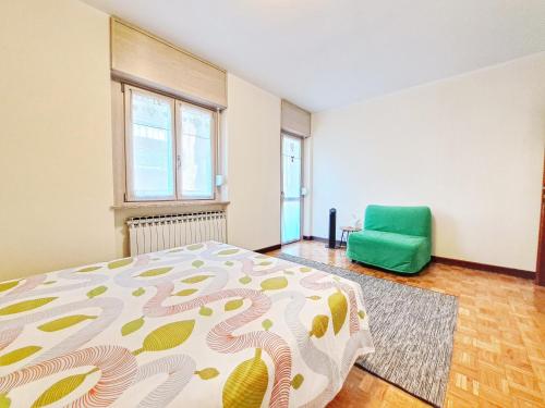 a bedroom with a bed and a green chair at Casa Alpina - Appartamento Aosta in Aosta