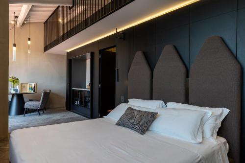 a bedroom with a large bed with white pillows at Suite Limonaia in San Gimignano