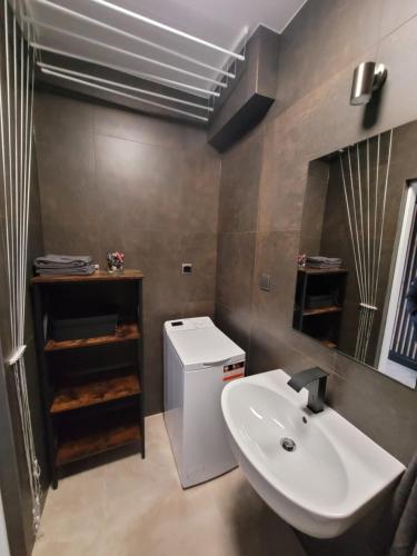 uma casa de banho com um lavatório e um WC. em LUX Apartament em Chrzanów