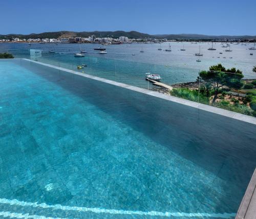 een groot zwembad met uitzicht op het water bij INNSiDE by Meliá Ibiza Beach in San Antonio Bay