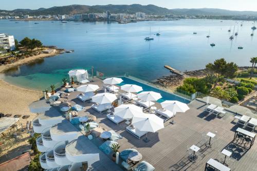 una vista aérea de una playa con sombrillas blancas en INNSiDE by Meliá Ibiza Beach en Bahía de San Antonio