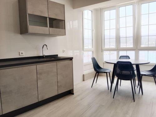 ビベイロにあるLa casa de Conchaのキッチン(テーブル、椅子、シンク付)