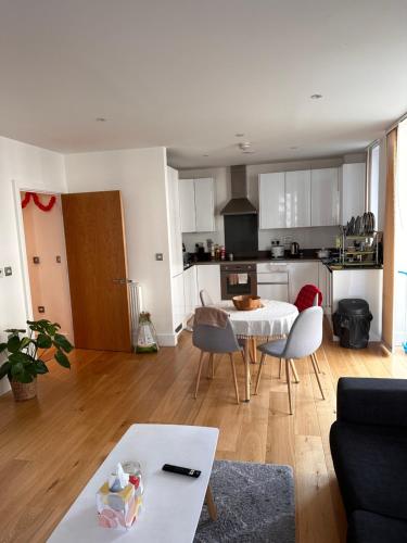 uma cozinha e sala de estar com mesa e cadeiras em Lovely Stay near Central London em Londres