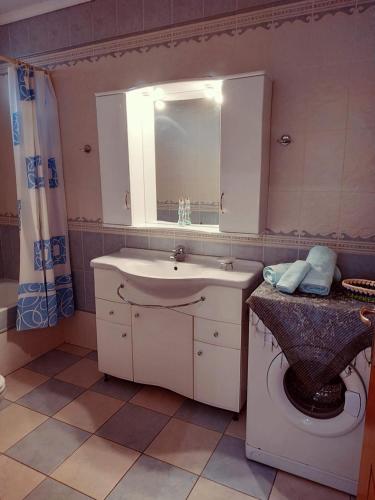 a bathroom with a sink and a toilet with a mirror at Central Moudros apartments in Moúdhros
