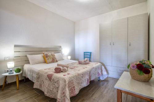 a bedroom with a bed with two stuffed animals on it at Endless Summer Apartment in Isola Rossa