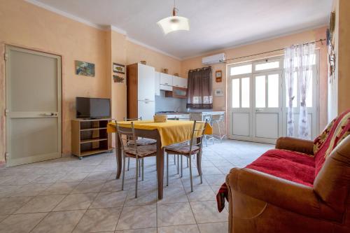 a living room with a table and a kitchen at Casa Loretta 2 in Valledoria