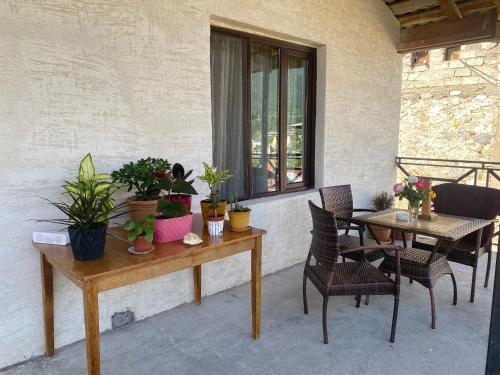un patio con mesa, sillas y plantas en GUEST HOUSE ,, MEMORY'' en Mestia