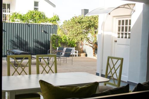 a patio with tables and chairs and a fence at Hermanus Champagne Accommodation in Hermanus