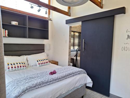 1 dormitorio con 1 cama grande y pared azul en Windsong Living Tree Living, en Krugersdorp