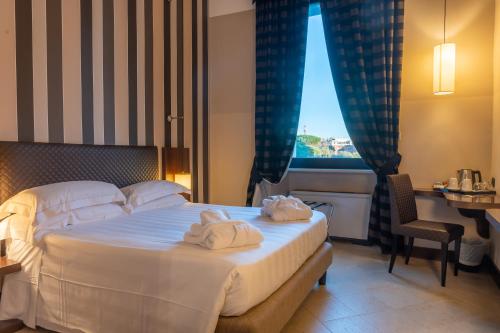 um quarto de hotel com uma cama com toalhas em TH Roma - Carpegna Palace em Roma